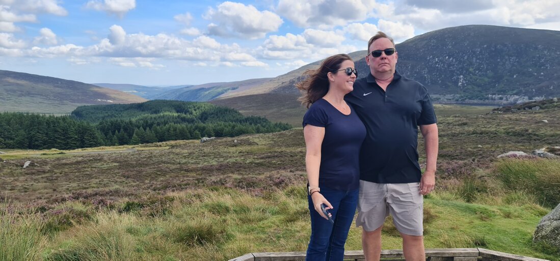 Hikers on a cliffside trail overlooking the sea